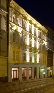 un edificio illuminato in una strada di città di notte di Hotel Patio Prague a Praga
