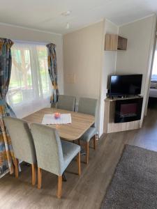 une salle à manger avec une table, des chaises et une télévision dans l'établissement Pension Quellenhof, à Wegberg