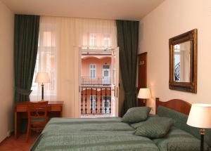una camera d'albergo con letto e finestra di Hotel Patio Prague a Praga