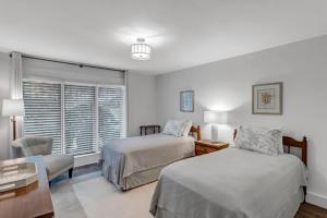 蓬特韋德拉海灘的住宿－Sweet Retreat，一间卧室设有两张床、一张桌子和一个窗口。