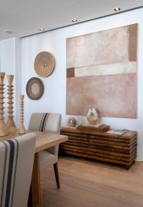 a dining room with a table and a painting on the wall at The Nici Clifton Sea View Apartments in Cape Town