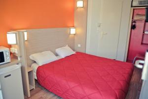 - une chambre avec un lit rouge et une couverture rouge dans l'établissement Premiere Classe Beauvais, à Beauvais