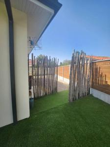 ogród z ogrodzeniem i zieloną trawą w obiekcie CHEZ CED - Gujan-Mestras / Bassin d'Arcachon w mieście Gujan-Mestras