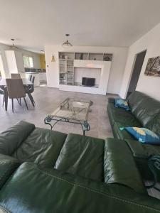 ein Wohnzimmer mit einem grünen Sofa und einem Tisch in der Unterkunft CHEZ CED - Gujan-Mestras / Bassin d'Arcachon in Gujan-Mestras