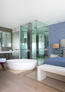 a large bathroom with a tub and a bed at The Nici Clifton Sea View Apartments in Cape Town