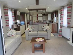 a living room with two couches and a table at alphi3 in Bude