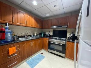 a kitchen with wooden cabinets and a stove top oven at Luxery home with stunning sea view in Ajman 