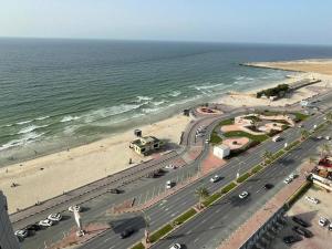 Luxery home with stunning sea view في عجمان: اطلالة جوية على طريق بجانب شاطئ
