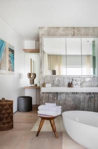 a bathroom with a tub and a mirror at The Nici Clifton Sea View Apartments in Cape Town +81 photos