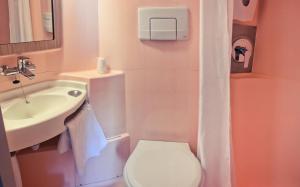 a bathroom with a white toilet and a sink at Premiere Classe Beauvais in Beauvais