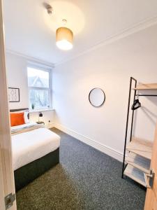 a white room with a bed and a window at Stunning Flat Close to Beach in Swansea