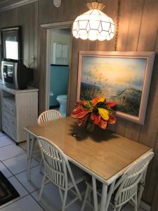 a dining room table with a vase of flowers on it at The Grove in Delray Beach +7 photos