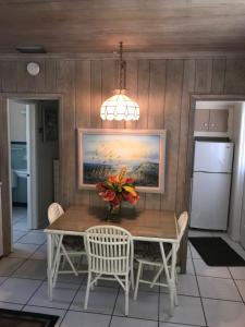 a dining room table with a vase of flowers on it at The Grove in Delray Beach