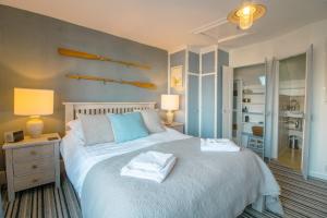 a bedroom with a bed with two towels on it at Cormorant- Sea View, Couples Retreat in Brixham