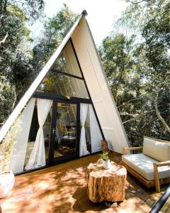 a screened in porch with a tree stump in front of a house at Salto Suizo Parque Ecologico in Independencia