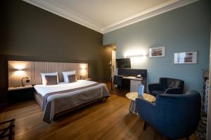 una camera d'albergo con letto e sedia di La Villa des Fleurs a Spa