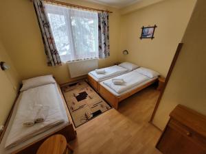Cette petite chambre comprend 2 lits et une fenêtre. dans l'établissement Penzión Slnečný dvor, à Zázrivá