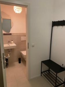 een badkamer met een wastafel, een toilet en een spiegel bij Hof Busen Malibu in Mönchengladbach