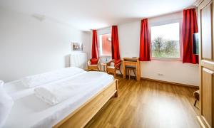 a bedroom with a large bed and red curtains at Hotel Lafette in Hinterzarten