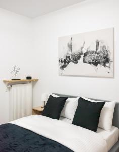 Schlafzimmer mit einem Bett mit schwarzen und weißen Kissen in der Unterkunft Bliska Wola Navy Blue Business Apartment in Warschau