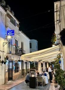 a group of people sitting at tables on a street at night at Las Brisas Estepona in Estepona