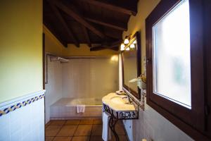 a bathroom with a tub and a sink and a mirror at Cigarral de Caravantes in Toledo