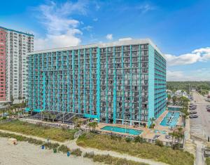 a large blue building with a swimming pool next to a beach at Landmark 830 in Myrtle Beach