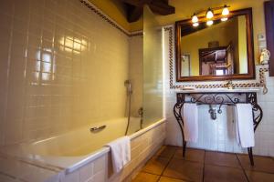 a bathroom with a tub and a mirror at Cigarral de Caravantes in Toledo