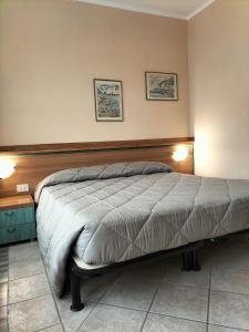 a bed in a bedroom with two pictures on the wall at Hotel Ala Bianca in Ameglia