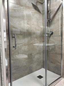 doccia con porta in vetro e servizi igienici di Hotel Ala Bianca ad Ameglia