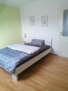 1 dormitorio con 1 cama con edredón azul en Muldenblick DG Wohnung, en Trebsen