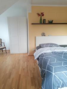 1 dormitorio con 1 cama y suelo de madera en Muldenblick DG Wohnung, en Trebsen