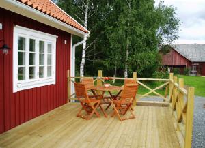een houten terras met een tafel en stoelen erop bij Skillingaryds Gård in Skillingaryd