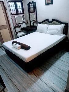 a bedroom with a large bed with white sheets and pillows at Grand tower Chennai in Chennai