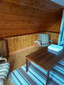 Cabaña de madera con mesa de madera y silla en Mariannelund cottage, en Mariannelund