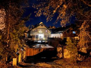 una casa è vista attraverso gli alberi di notte di Penzión Evka a Poprad