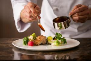 uno chef che mangia un piatto di cibo su un tavolo di Hotel Metropolitan Morioka New Wing a Morioka