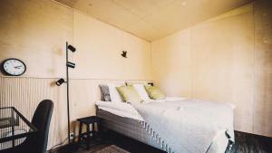 1 dormitorio con 1 cama y reloj en la pared en Venejoen Piilo - Naava, en Romppala