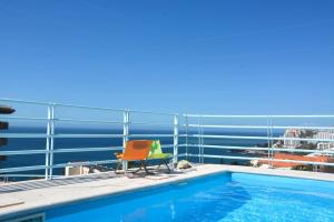 een balkon met een zwembad en 2 stoelen bij Sol do Lido 2 in Funchal