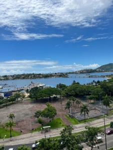 - une vue sur un parc et une étendue d'eau dans l'établissement Praia do Canto Apart Hotel Frente Mar, à Vitória