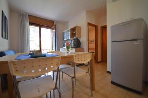 a kitchen with a table and a refrigerator at Villaggio Dei Gelsomini in Bibione