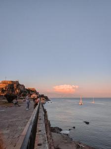 a man standing on a beach near the water at Elise Corfu City Apartment in Ágios Rókkos
