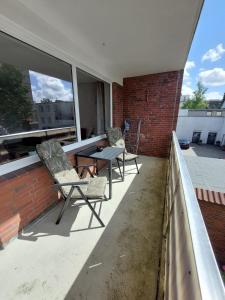 een patio met 2 stoelen en een tafel op een balkon bij Fewo am Kurpark mit Balkon in Wilhelmshaven