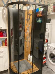 uma cabina de duche numa cozinha com uma máquina de lavar roupa em La Fossette em Asnelles