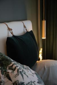 a black pillow sitting on a bed next to a lamp at Privatzimmer - Sieben an der Donau in Ottensheim