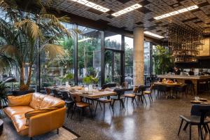 a restaurant with tables and chairs and windows at Play Midtown Hotel Tel Aviv in Tel Aviv