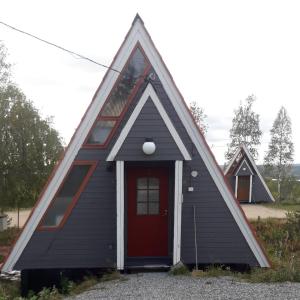 ein kleines Haus mit einer roten Tür in der Unterkunft Karemajat superb cottage in Ylitornio