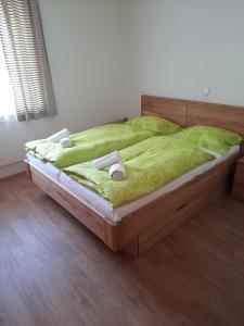 uma cama com lençóis verdes e duas toalhas em Haus Bruna by Globalimmoservice em Bad Kleinkirchheim