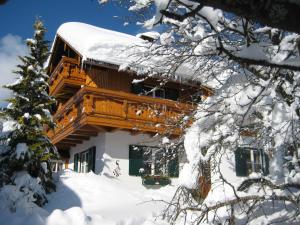 a log cabin in the snow with snow covered trees at Haus Schrei in Grundlsee