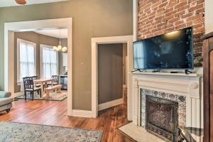 a living room with a fireplace with a tv above it at Bright Apartment, Near Vicksburg Military Park! in Vicksburg